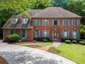 Beautiful brick home featuring a well-maintained lawn, colorful shutters, and a welcoming entrance at 2910 Leeds Garden Ln, Alpharetta, GA 30022