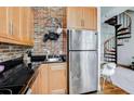 Functional kitchen with stainless steel appliances, brick backsplash, and wood cabinets at 30 5Th Ne St # 1006, Atlanta, GA 30308