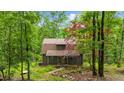 Secluded log home surrounded by lush greenery and mature trees, offering privacy at 15 Bailey St, Whitesburg, GA 30185