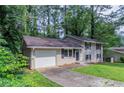 Split-level home with an attached garage and dark shutters at 1539 Pine Glen Cir, Decatur, GA 30035