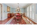Elegant dining room with hardwood floors, wainscoting, and a stylish chandelier at 11880 Wexford Club Dr, Roswell, GA 30075