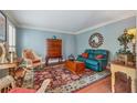 Cozy living room featuring a comfortable blue sofa, hardwood floors, and natural light at 11880 Wexford Club Dr, Roswell, GA 30075