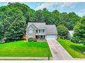 Inviting home with a manicured lawn, mature trees, and a welcoming front porch at 2314 Robin Dr, Loganville, GA 30052