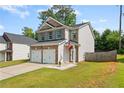 Well-maintained two-story home featuring a two-car garage, lush lawn, and classic siding details at 154 Stephens Mill Dr, Dallas, GA 30157