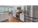 Bright kitchen with stainless steel appliances, granite countertops, and a view into the living area at 2245 Long Bow Chase, Kennesaw, GA 30144