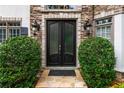Elegant double front doors framed by stone accents and manicured shrubs, enhancing the entrance at 1515 Lockridge Dr, Cumming, GA 30041