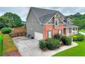 Side view showcasing the home's brick and siding, attached garage, and well-maintained landscaping enhancing curb appeal at 3145 Sweet Basil Ln, Loganville, GA 30052