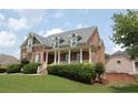 Beautiful two-story home with a classic brick facade, covered porch, and lush green lawn at 3145 Sweet Basil Ln, Loganville, GA 30052