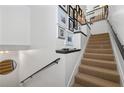Staircase features carpeted treads, white walls with art, and black railings, leading to an upstairs area at 4248 River Green Dr # 305, Atlanta, GA 30327