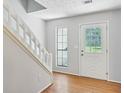 Entryway with hardwood floors, staircase, and white door at 1925 Sailcloth St, Lithonia, GA 30058