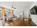 Cozy living room with hardwood floors, a ceiling fan, and a large window offering a scenic view at 1755 Fairburn Sw Rd, Atlanta, GA 30331