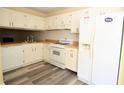 Functional kitchen featuring white cabinets, appliances, and laminate flooring at 775 Heritage Valley Rd, Norcross, GA 30093
