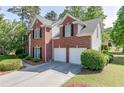 Rear exterior of a brick house, highlighting the two-car garage and well-kept lawn at 1008 Post Horn Run, Lawrenceville, GA 30045