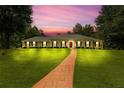 Stunning ranch-style home with a lush green lawn and a striking red front door at sunset at 3244 Beechwood Se Dr, Marietta, GA 30067