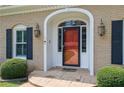 Close-up of the front door featuring an arched entryway, decorative sidelights, and vintage-style sconces at 3244 Beechwood Se Dr, Marietta, GA 30067