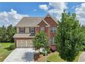 Beautiful two-story brick home featuring a manicured lawn and two-car garage at 4480 Egret Ave, Cumming, GA 30041