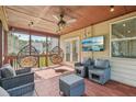Inviting screened porch with cozy chairs, TV, and hanging swing seats at 4480 Egret Ave, Cumming, GA 30041
