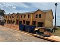 Exterior of a new construction townhome featuring unfinished siding and blue bins at 1346 Riverstone Rd # 107, Jonesboro, GA 30238