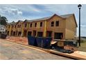 Exterior of a new construction townhome featuring unfinished siding and blue bins at 1346 Riverstone Rd # 107, Jonesboro, GA 30238