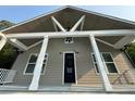 Eye-level, low angle shot of a home's entrance with white columns and a modern black door at 1713 Cagle Ct, Lawrenceville, GA 30045