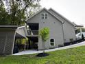 Side view of a modern home with a covered patio, lush landscaping, and a gray exterior at 1713 Cagle Ct, Lawrenceville, GA 30045