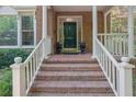 Inviting brick porch with white railings, planters, and a stylish front door with transom window at 2010 Riverside Rd, Roswell, GA 30076