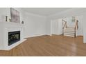 Spacious living room featuring a fireplace, hardwood floors, and staircase access at 2010 Riverside Rd, Roswell, GA 30076