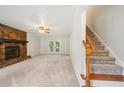 Bright living room featuring a stone fireplace, access to the back deck, and staircase to the second floor at 4772 Ridgewood Nw Ct, Acworth, GA 30102