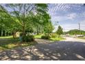 Street view of the property showcasing the home on a corner lot surrounded by mature trees and lush landscape at 2155 Rosedale Rd, Snellville, GA 30078