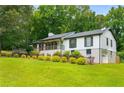 Well-kept home with front porch and attached garage nestled among mature trees at 117 Franklin Rd, Woodstock, GA 30188