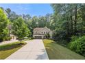 Two-story home with an attached garage, long driveway, and mature trees at 2740 Creekside Manor Dr, Powder Springs, GA 30127