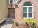 Close-up of the front entrance showcasing the brickwork, decorative window, seasonal wreath, and manicured landscaping at 3535 Fairgreen Ct, Douglasville, GA 30135