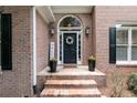 View of the entrance of a brick home with a wreath on the door and brick steps at 1418 Winborn Nw Cir, Kennesaw, GA 30152