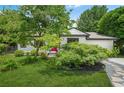 Manicured front lawn featuring a vibrant pink door, lush greenery, and large shade tree at 2296 N Shallowford Rd, Atlanta, GA 30341