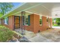 Inviting brick home showcasing a covered front porch with wrought iron details and a beautiful wood front door at 739 Pinehill Se Dr, Smyrna, GA 30080