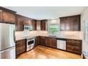 Updated kitchen features stainless steel appliances, granite countertops, dark wood cabinets, and hardwood flooring at 739 Pinehill Se Dr, Smyrna, GA 30080