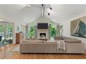 Bright living room boasts a vaulted ceiling, a fireplace, large windows, and an adjacent doorway at 11785 Mountain Laurel Dr, Roswell, GA 30075