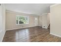 Bright living room featuring hardwood floors, large window, and staircase entrance at 2083 Green Forrest Dr, Decatur, GA 30032