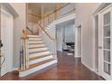 Elegant foyer with hardwood floors, staircase, and view into a living room at 4360 Canterbury Walk Dr, Duluth, GA 30097