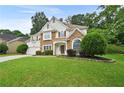 Attractive home with stone facade, mature landscaping, and a double garage on a green lawn at 4360 Canterbury Walk Dr, Duluth, GA 30097