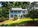 Charming two-story home with a well-manicured lawn, inviting walkway, and mature trees creating a serene setting at 1428 Brookcliff Dr, Marietta, GA 30062