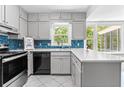 Bright kitchen featuring white cabinets, modern appliances, mosaic backsplash, and a large window with natural light at 1428 Brookcliff Dr, Marietta, GA 30062