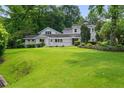 Large, well-maintained lawn and exterior view of this charming two-story home with mature trees at 6771 Sunny Brook Ln, Atlanta, GA 30328