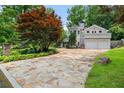 Stone driveway leading up to the house with a two-car garage, surrounded by landscaped greenery at 6771 Sunny Brook Ln, Atlanta, GA 30328