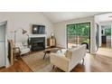 Cozy living room featuring a fireplace, hardwood floors, and sliding doors to the deck at 85 Dunwoody Springs Dr, Sandy Springs, GA 30328