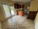 Functional kitchen featuring a breakfast bar, tiled floor, and access to the backyard at 6380 Mableton Sw Pkwy, Mableton, GA 30126