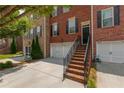 Beautiful two-story brick townhome featuring a spacious two-car garage and a welcoming brick staircase to the front door at 2264 Ewell Park Dr, Lawrenceville, GA 30043