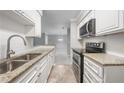 Modern kitchen featuring granite countertops, stainless steel appliances, and white subway tile backsplash at 23307 Plantation Ne Dr, Atlanta, GA 30324