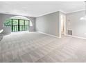 Bright living room with neutral carpet, grey paint, large arched window, and white trim at 23307 Plantation Ne Dr, Atlanta, GA 30324