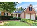 Beautiful brick home with a well-maintained lawn and garden, complemented by an attached two-car garage at 795 Lake Medlock Dr, Alpharetta, GA 30022